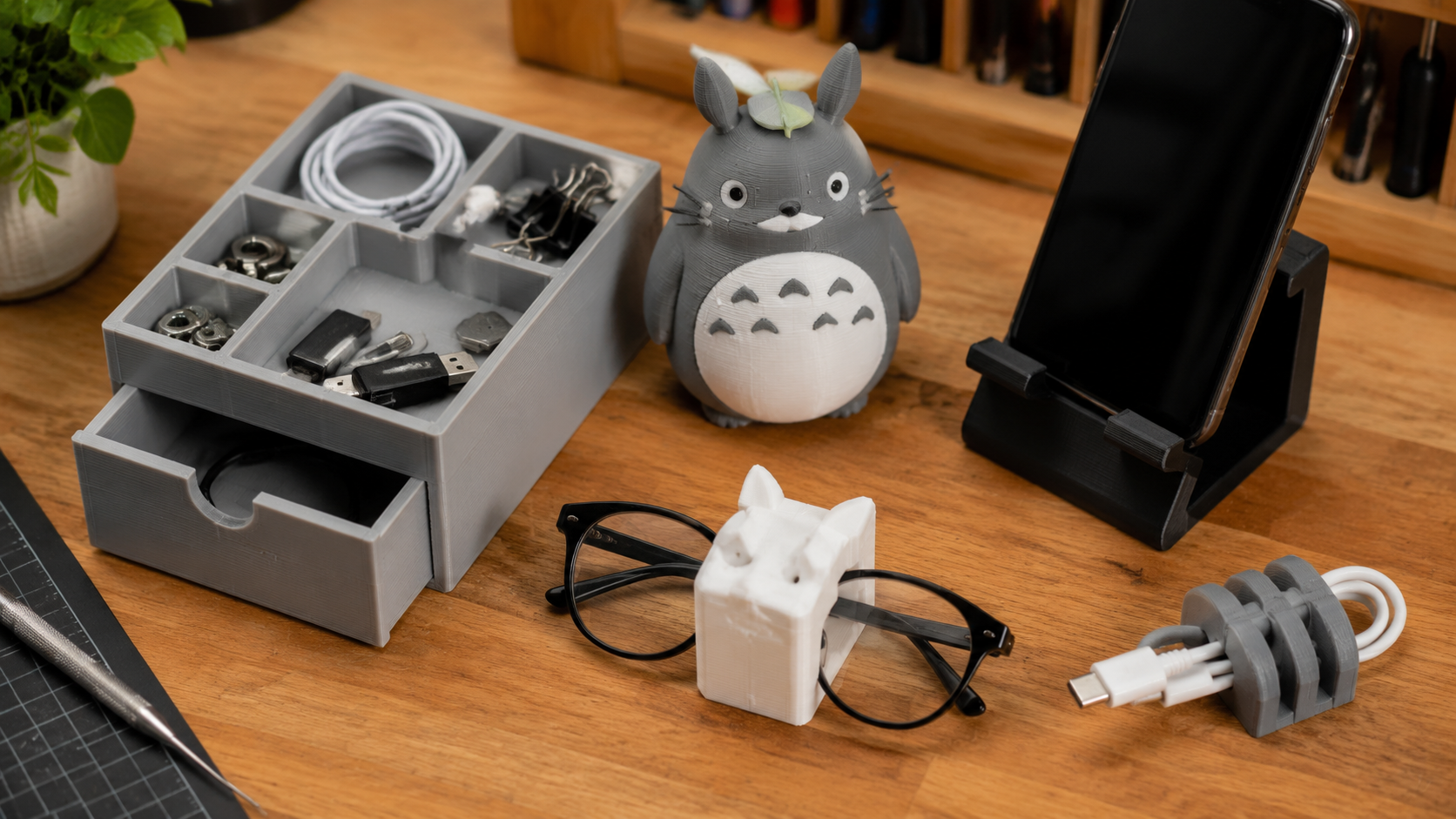 Various free 3D printer models on a workshop desk including organizers, miniatures and tools, free 3D printer models on DIY3D