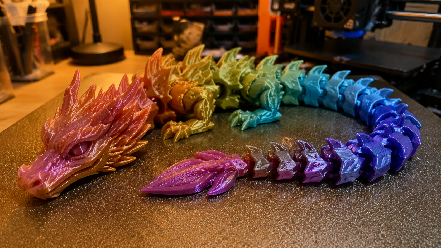 Articulated dragon 3D printed in silk PLA on a Bambu Lab A1 showing movable joints (free 3D models for printing category example)